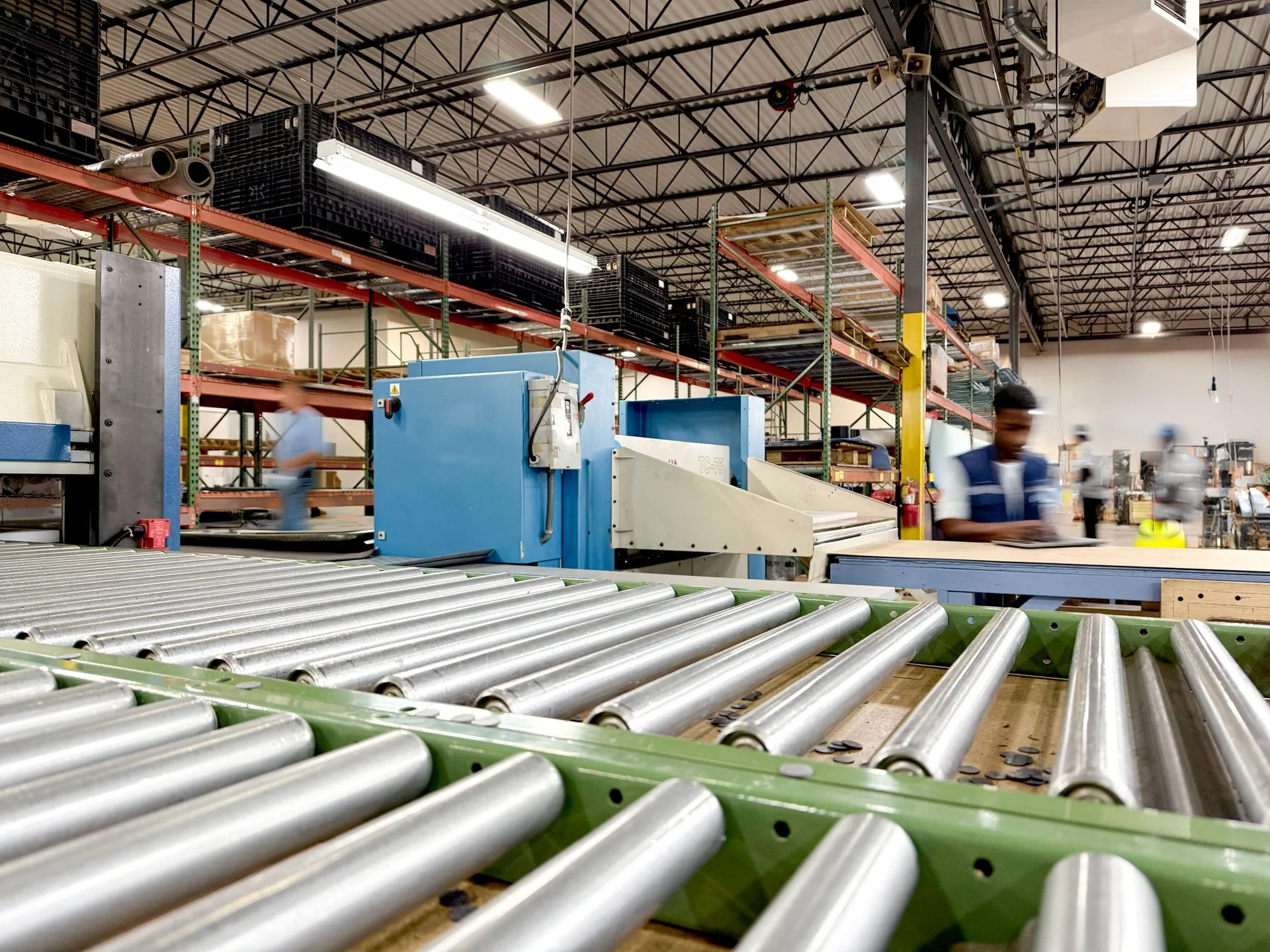 Industrial warehouse interior with conveyor belts and workers.